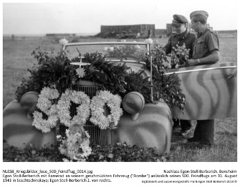 Egon Stoll-Berberich mit Kamerad an seinem geschmückten Fahrzeug ("Bombe") anlässlich seines 500. Feindflugs am 31. August 1943 in Seschtschinskaya; Egon Stoll-Berberich 2. von rechts. NLESB_Kriegsbilder_lose_500_Feindflug_0014. Egon Stoll-Berberich mit Kamerad an seinem geschmückten Fahrzeug ("Bombe") anlässlich seines 500. Feindflugs am 31. August 1943 in Seschtschinskaya; Egon Stoll-Berberich 2. von rechts. NLESB_Kriegsbilder_lose_500_Feindflug_0014.