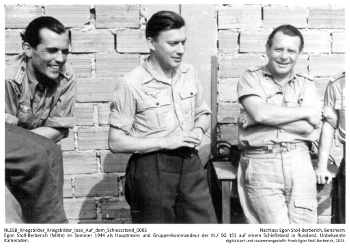 Egon Stoll-Berberich (Mitte) im Sommer 1944 als Hauptmann und Gruppenkommandeur der III./S.G. 151 auf einem Schießstand in Russland. Unbekannte Kameraden. NLESB_Kriegsbilder_Kriegsbilder_lose_Auf_dem_Schiessstand_0005