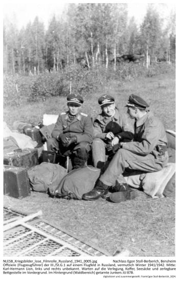 Offiziere (Flugzeugführer) der III./St.G.1 auf einem Flugfeld in Russland, vermutlich Winter 1941/1942. Mitte: Karl-Hermann Lion, links und rechts unbekannt. Warten auf die Verlegung, Koffer, Seesäcke und zerlegbare Bettgestelle im Vordergrund. Im Hintergrund (Waldbereich) getarnte Junkers JU 87B. NLESB_Kriegsbilder_lose_Filmrolle_Russland_1941_0005 Offiziere (Flugzeugführer) der III./St.G.1 auf einem Flugfeld in Russland, vermutlich Winter 1941/1942. Mitte: Karl-Hermann Lion, links und rechts unbekannt. Warten auf die Verlegung, Koffer, Seesäcke und zerlegbare Bettgestelle im Vordergrund. Im Hintergrund (Waldbereich) getarnte Junkers JU 87B. NLESB_Kriegsbilder_lose_Filmrolle_Russland_1941_0005