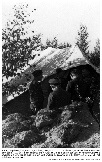 Zelte der III./St.G. 1 auf einem Feldflugplatz in Russland. Die Zelte sind in den Boden eingelassen, Erdwälle umgeben die Unterkünfte zusätzlich, um Splitterschutz zu gewährleisten. Karl-Hermann Lion (3. v. l.) mit unbekannten Kameraden. NLESB_Kriegsbilder_lose_Filmrolle_Russland_1941_0033 Zelte der III./St.G. 1 auf einem Feldflugplatz in Russland. Die Zelte sind in den Boden eingelassen, Erdwälle umgeben die Unterkünfte zusätzlich, um Splitterschutz zu gewährleisten. Karl-Hermann Lion (3. v. l.) mit unbekannten Kameraden. NLESB_Kriegsbilder_lose_Filmrolle_Russland_1941_0033