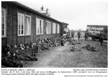 Soldaten der 9. St.G. 2 bei einer Rast auf einem Feldflugplatz im Spätsommer 1939, vermutlich kurz vor Kriegsbeginn. Fahrzeug verweist auf Raum Köslin (heutiges Koszalin in Polen). NLESB_Kriegsbilder_Album1_0074.