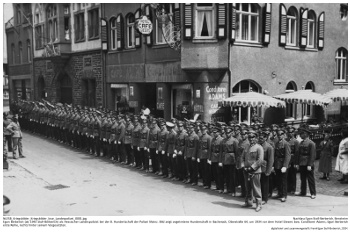 Egon Berberich (ab 1943 Stoll-Berberich) als Hessischer Landespolizist bei der 8. Hundertschaft der Polizei Mainz. Bild zeigt angetretene Hunderschaft in Bacherach, Oberstraße 64, um 1934 vor dem Hotel Giesers bzw. Conditorei Adams; Egon Berberich erste Reihe, rechts hinter seinem Vorgesetzten. NLESB_Kriegsbilder_Kriegsbilder_lose_Landespolizei_0001 Egon Berberich (ab 1943 Stoll-Berberich) als Hessischer Landespolizist bei der 8. Hundertschaft der Polizei Mainz. Bild zeigt angetretene Hunderschaft in Bacherach, Oberstraße 64, um 1934 vor dem Hotel Giesers bzw. Conditorei Adams; Egon Berberich erste Reihe, rechts hinter seinem Vorgesetzten. NLESB_Kriegsbilder_Kriegsbilder_lose_Landespolizei_0001