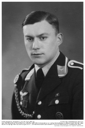 Egon Stoll-Berberich als Unteroffizier der Luftwaffe, April 1938. Schützenschnur von rechter Schulterklappe zu zweitem Knopf, über der linken Brusttasche Spange "Dienstauszeichnung IV. Klasse",  auf linker Brusttasche Sportabzeichen "Deutscher Reichsbund für Leibesübungen (DRL)". NLESB Kriegsbilder Kriegsbilder lose P01 Egon 0006.
