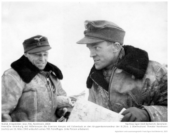 Feierliche Verleihung des Ritterkreuzes des Eisernen Kreuzes mit Eichenlaub an den Gruppenkommandeur der III./St.G. 1 Oberleutnant Theodor Nordmann (rechts) am 16. März 1943 anlässlich seines 700. Feindfluges. Nebenstehende Personen unbekannt. NLESB_Kriegsbilder_lose_P06_Nordmann_0004.
